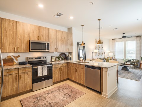 A kitchen with wooden cabinets and a large island.