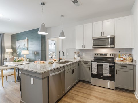 A modern kitchen with a stainless steel oven and granite countertops.