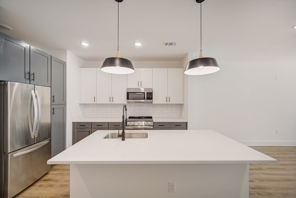 A modern kitchen with a large island and stainless steel appliances.