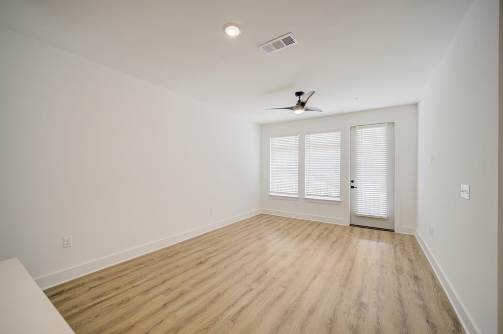 A room with a ceiling fan and a door with a window.