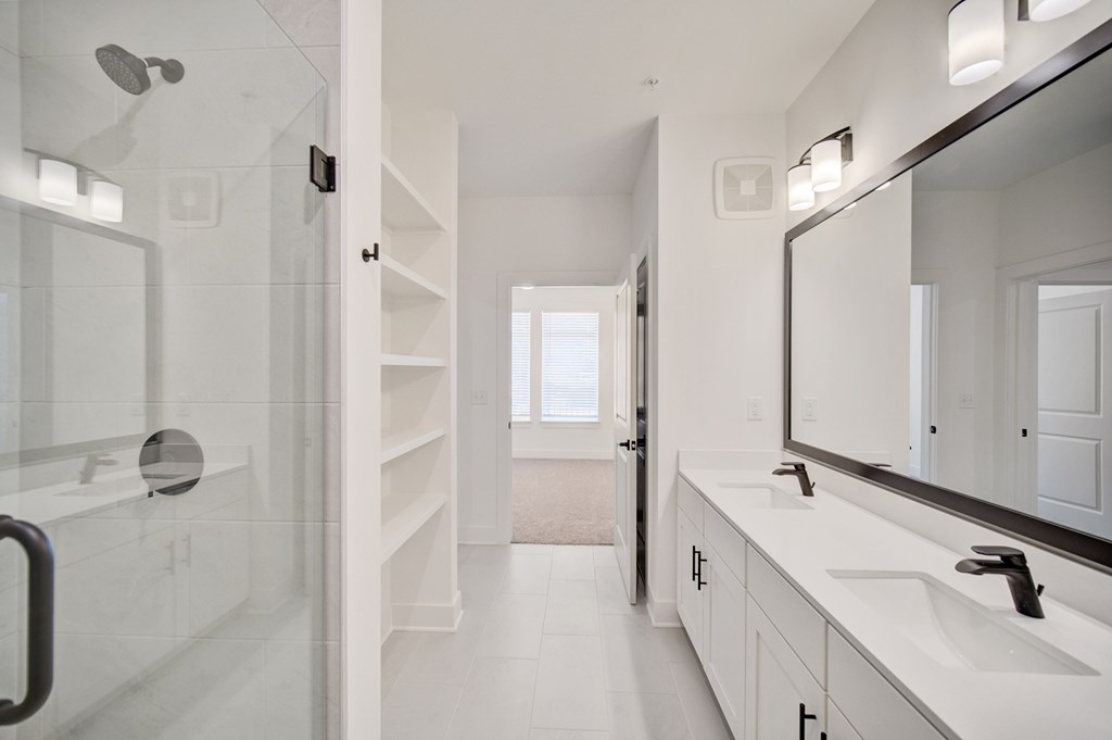 A white bathroom with a walk in shower.
