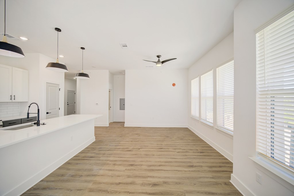 A kitchen with a white countertop and a wooden floor.