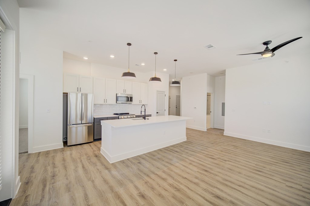 A kitchen with a refrigerator, sink, and stove is shown.