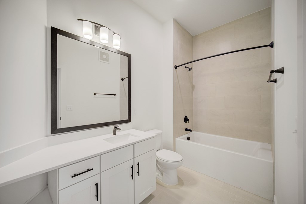A white bathroom with a sink, toilet, and bathtub.