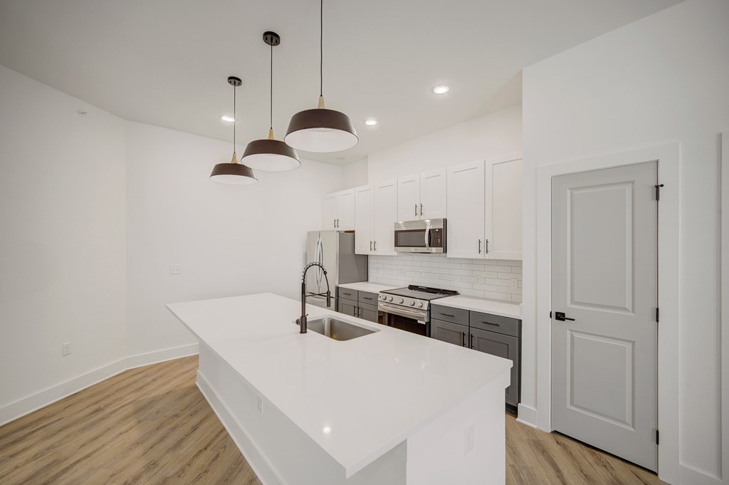 A kitchen with a white countertop and a sink.