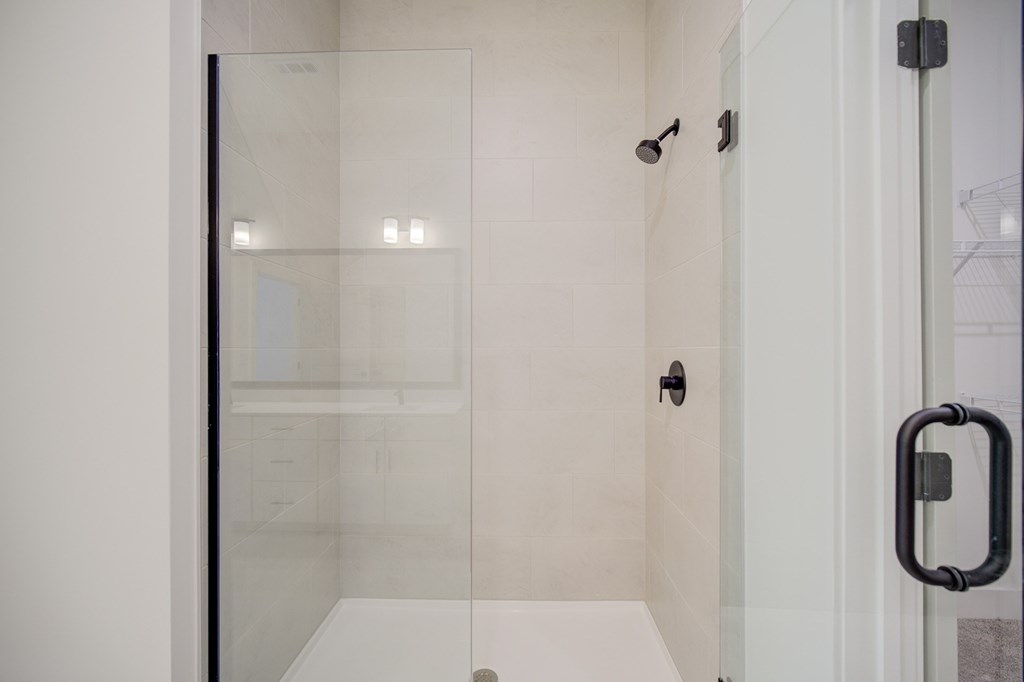 A white bathroom with a glass shower door.