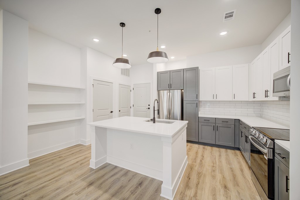 A modern kitchen with white cabinets and a central island.