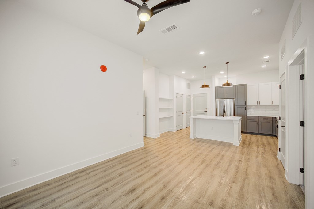 A room with a ceiling fan and a red ball on the wall.
