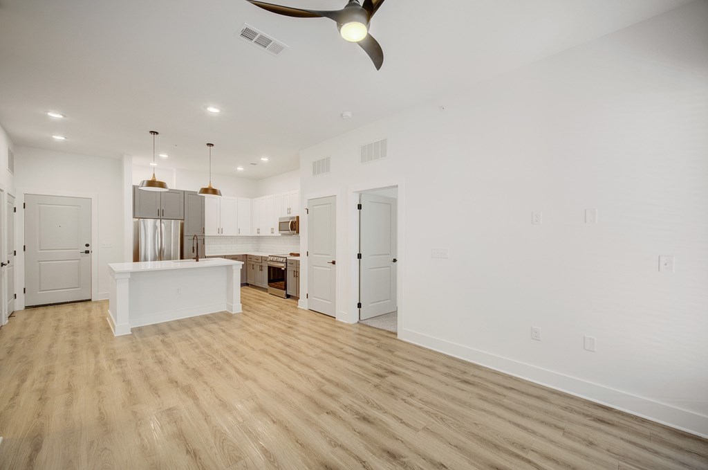 A spacious room with a white island in the middle and a ceiling fan.