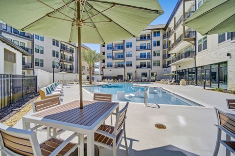 Panama City Beach, FL, Apartments Near Pirates Voyage - Vintage Lake Powell - Swimming Pool With Lounge Chairs, Patio Tables, And Large Umbrellas.