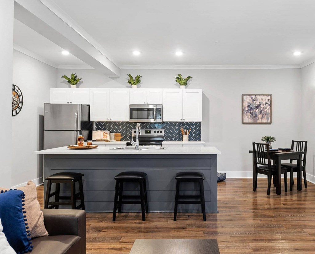 an open kitchen and dining area with a counter and a refrigerator