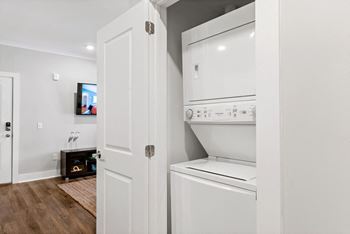 a white washer and dryer in a room with a white door