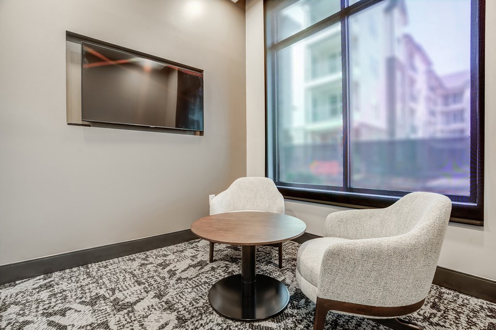 a small table and two chairs in a room with a large window