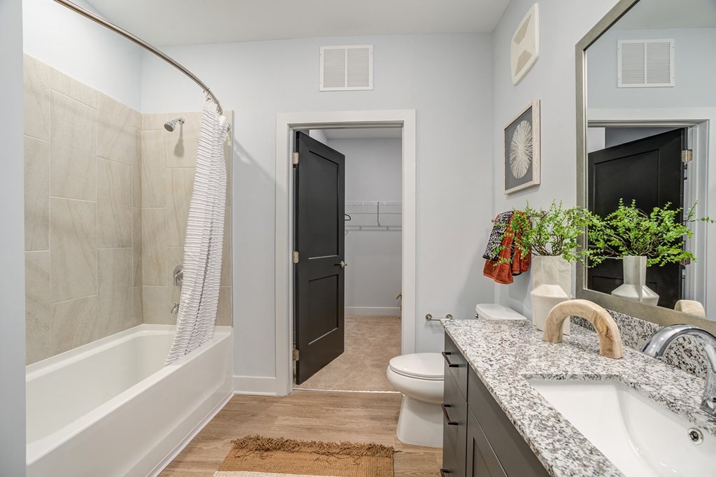 a bathroom with gray walls and a white bathtub