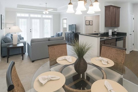 A modern dining room with a glass table and chairs.