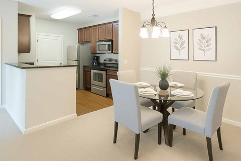 A kitchen with a dining table and chairs.