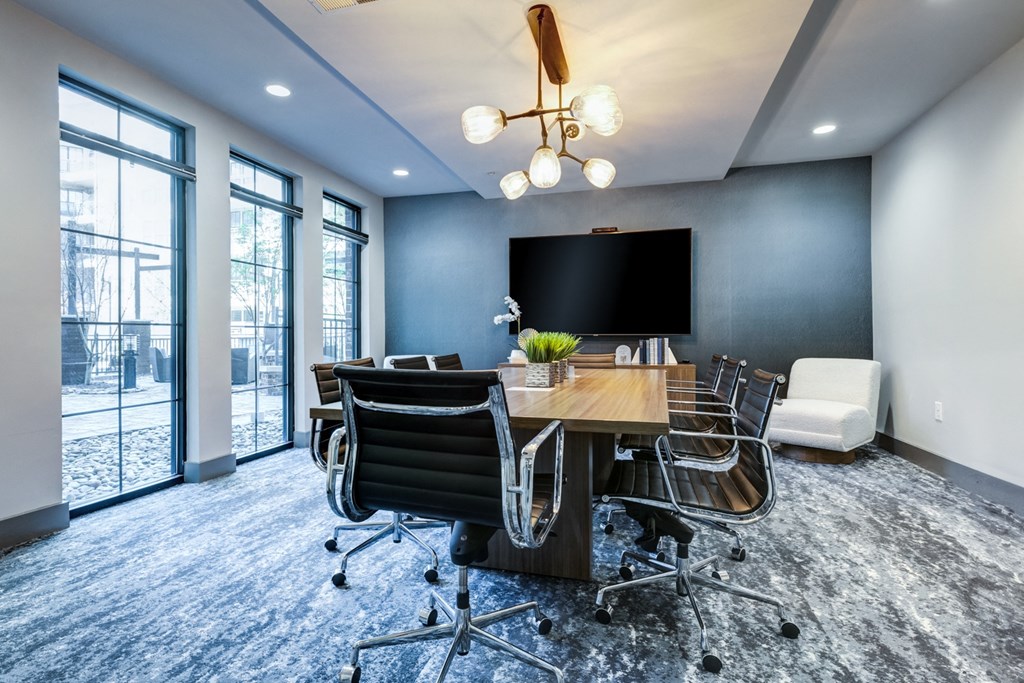 a conference room with a table and chairs and a tv