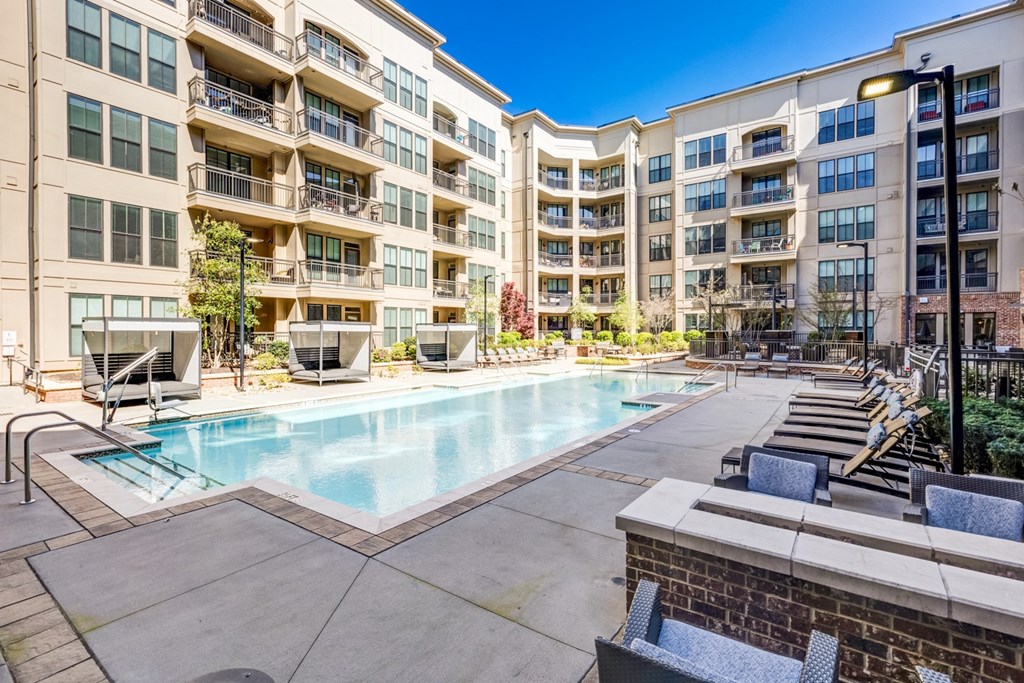 a swimming pool with an apartment building in the background