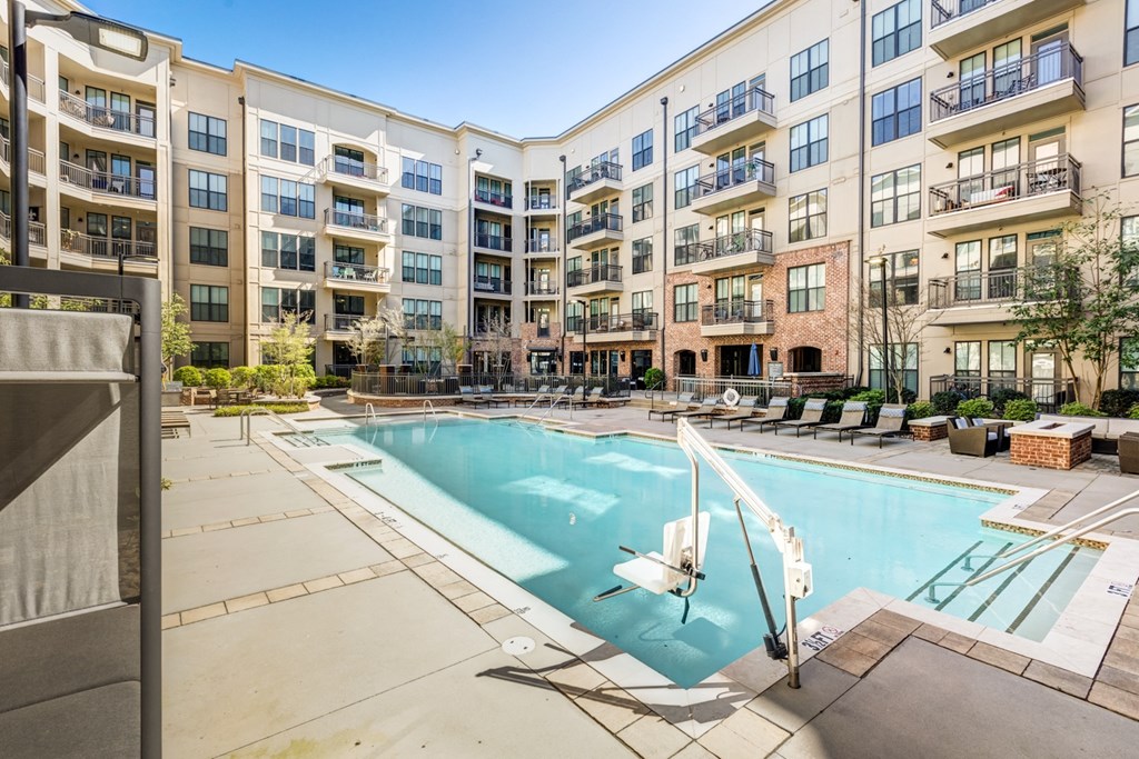 a swimming pool with an apartment building in the background