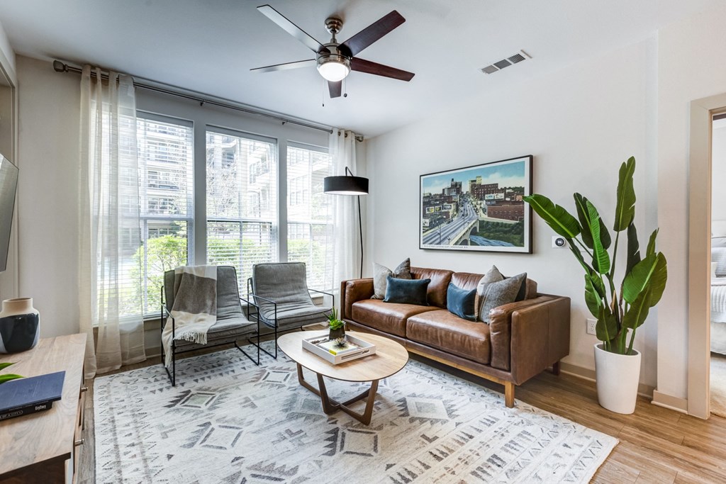 a living room with a couch and a chair and a ceiling fan