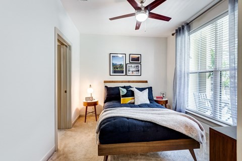 a bedroom with a bed and a ceiling fan