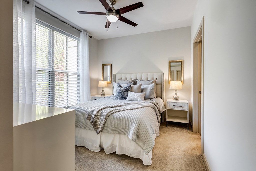 a bedroom with a bed and a ceiling fan