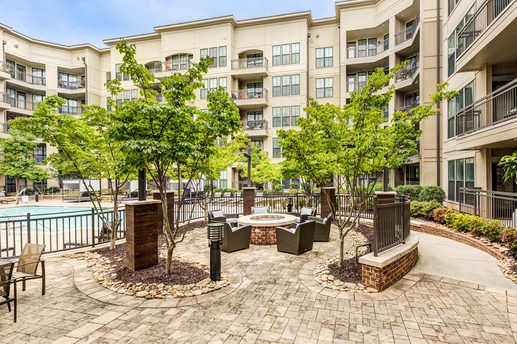 a courtyard with a pool and trees in front of an apartment building