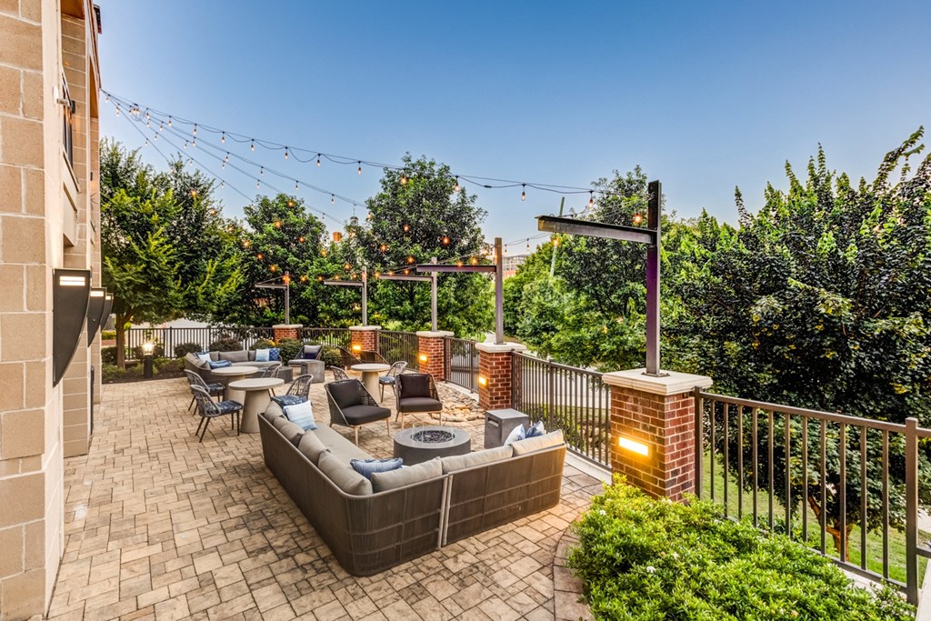 a patio with couches and chairs and a fire pit
