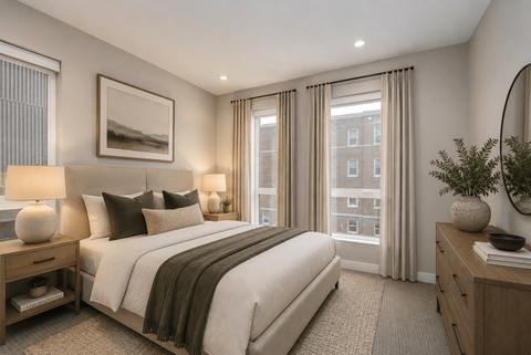 A bedroom with a large bed, a nightstand, and a window with curtains.