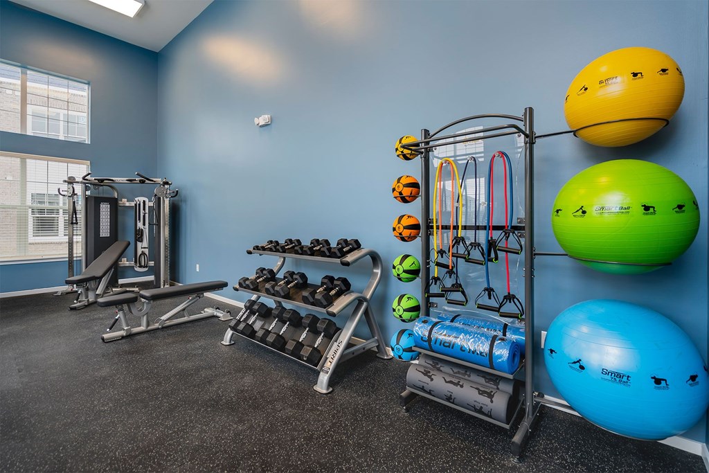 A gym with blue walls and a variety of exercise equipment.