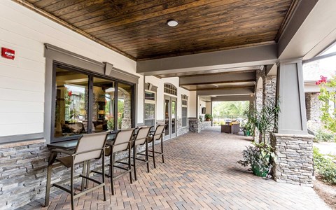 a covered patio with a table and chairs