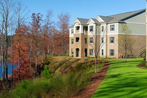 A large building with a green lawn in front of it.