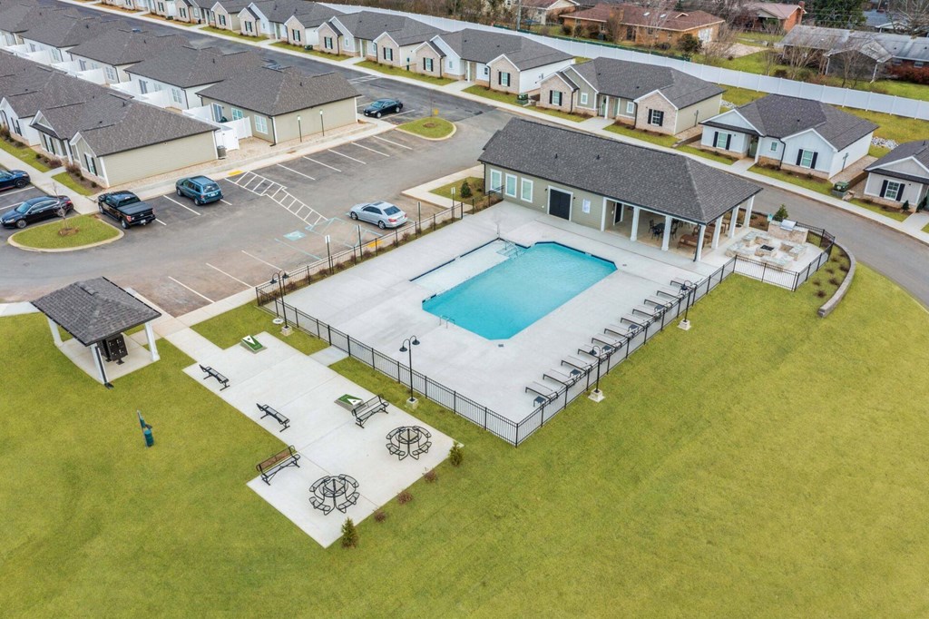 an aerial view of a swimming pool in front of a house
