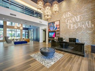 a large lobby with a reception desk and chandeliers at Altis Grand Central, Tampa, 33606 - Photo Gallery 4