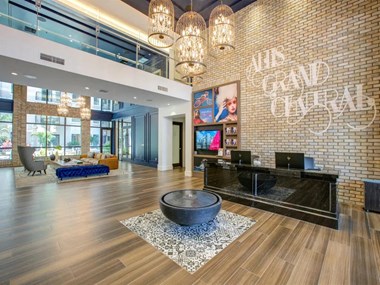 a large lobby with a reception desk and chandeliers - Photo Gallery 4