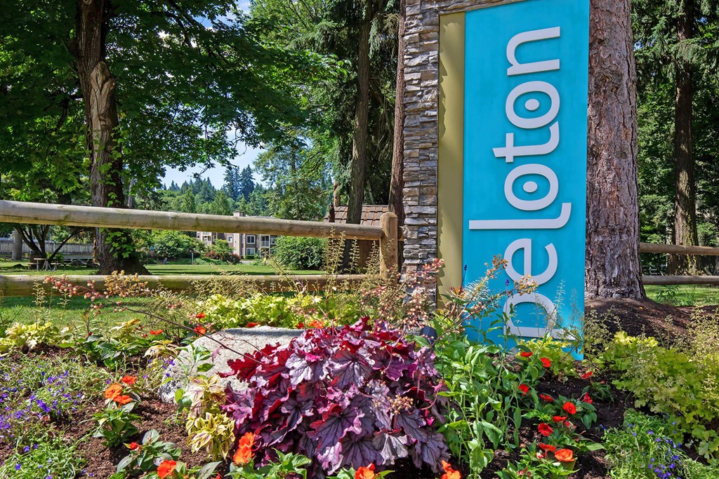 a blue welcome sign in front of a garden