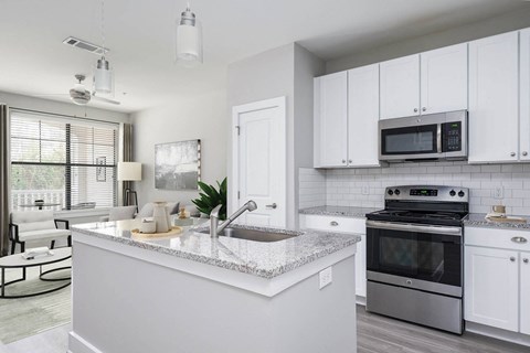 an open kitchen with white cabinets and a counter top