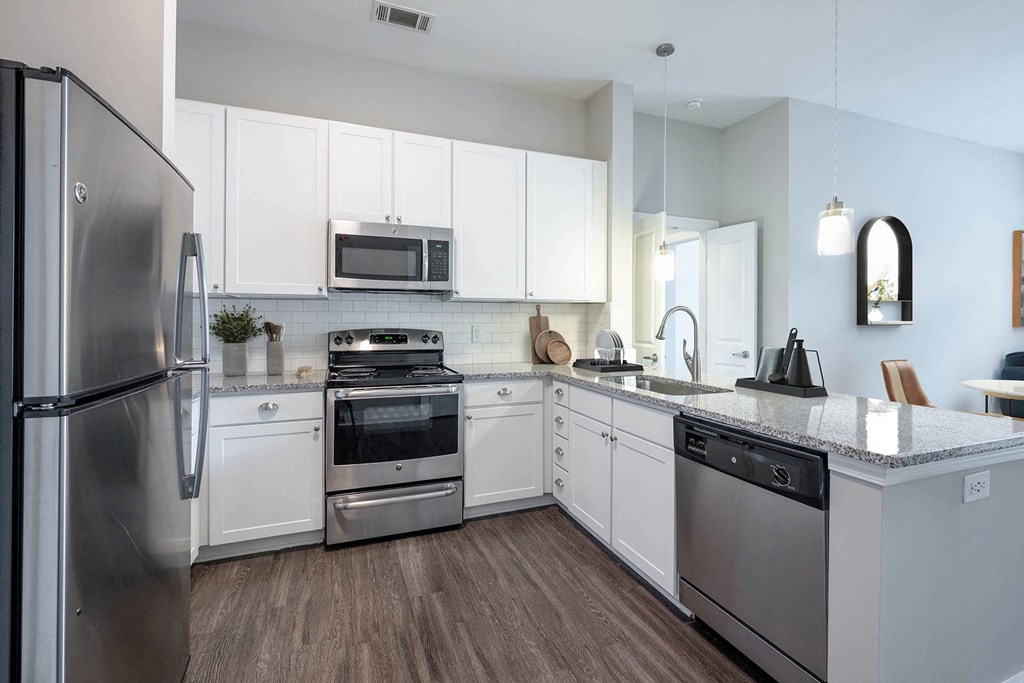 a kitchen with white cabinets and stainless steel appliances