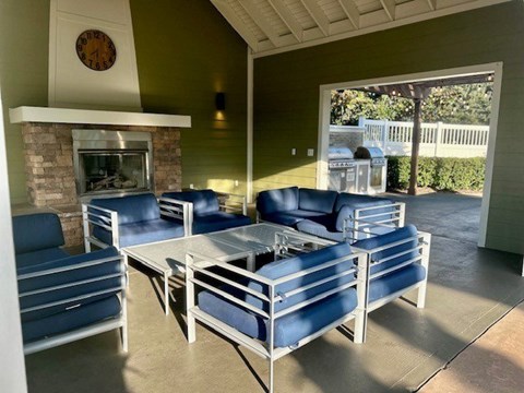 A living room with blue chairs and a fireplace.