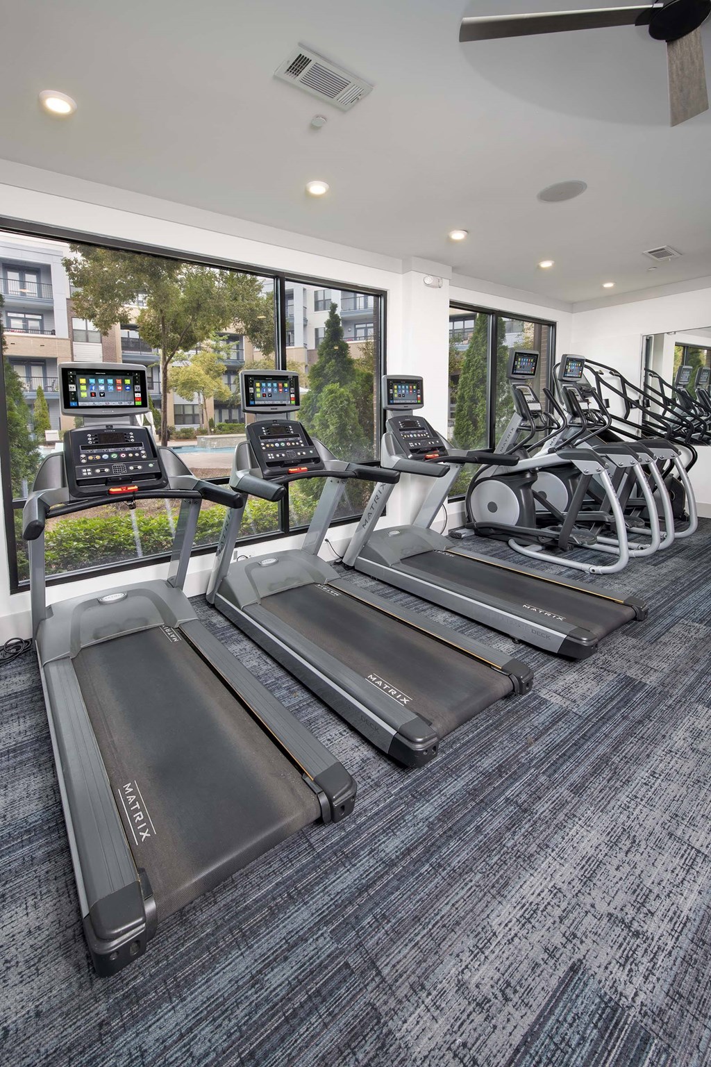 A gym with treadmills and elliptical machines.
