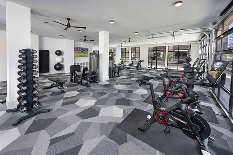 A gym with a variety of equipment including treadmills, weights, and exercise machines.