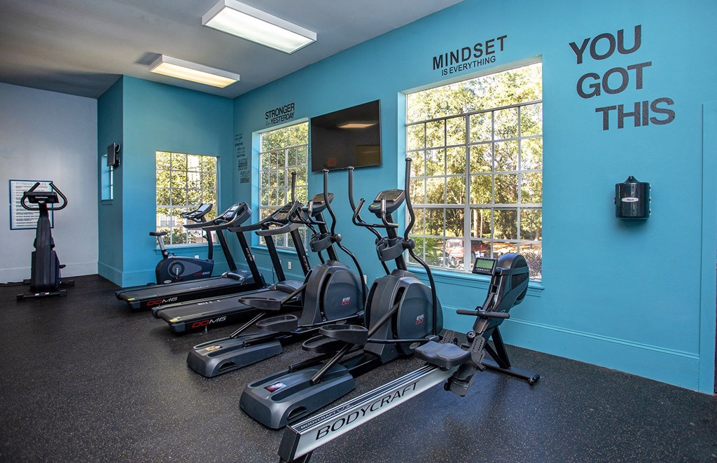 a room filled with cardio equipment and a large window