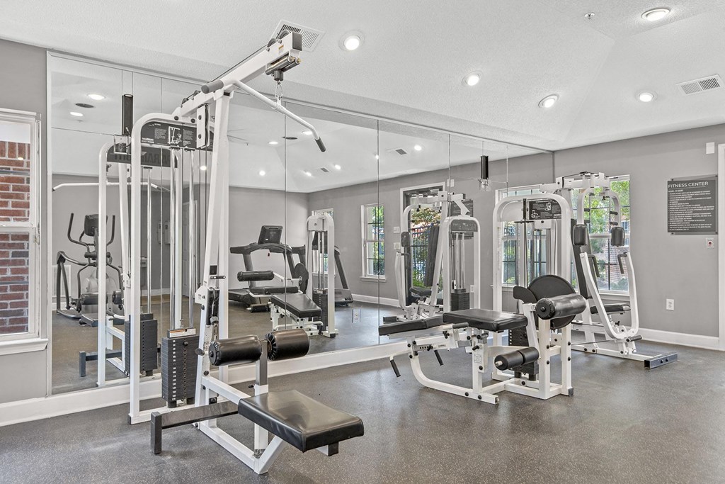 A gym with a variety of equipment including a leg press machine.