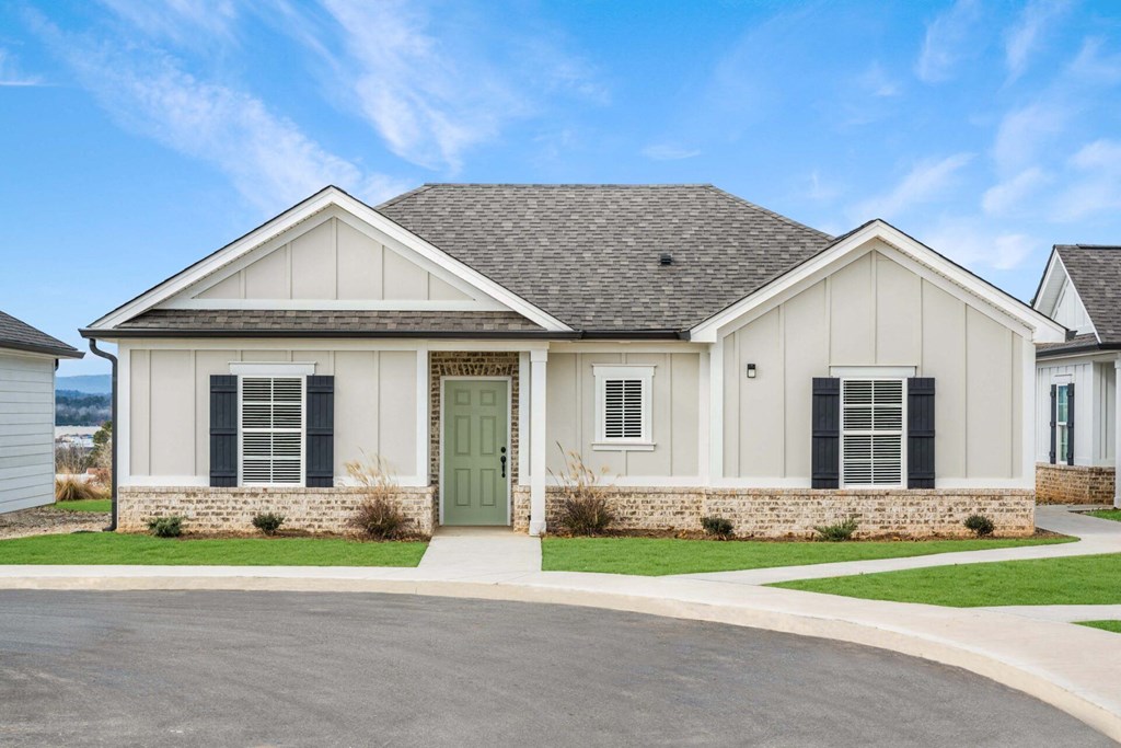a white house with a green door and a driveway