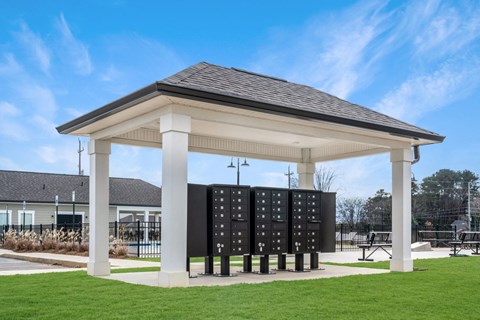 a pavilion with a green lawn and a tennis court