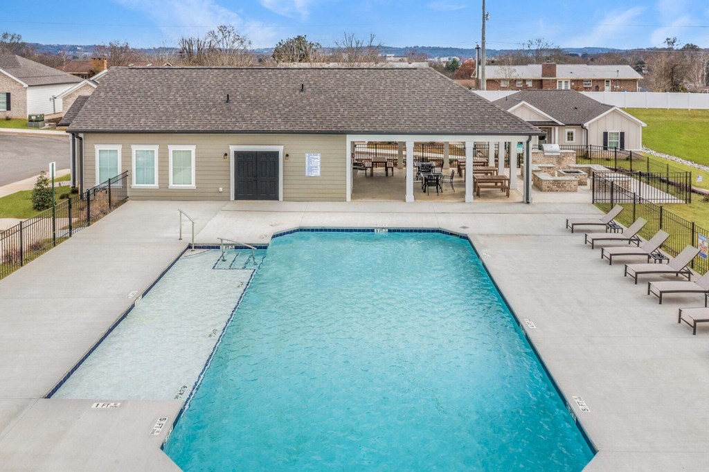a swimming pool with a house in the background