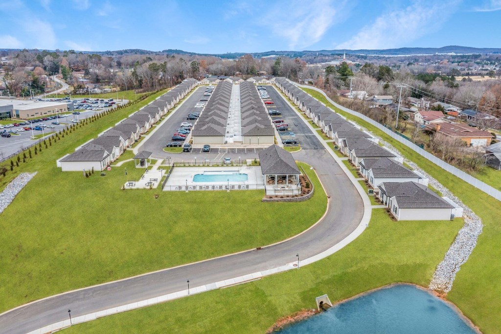 an aerial view of a parking lot with a pool and cars in the parking lot