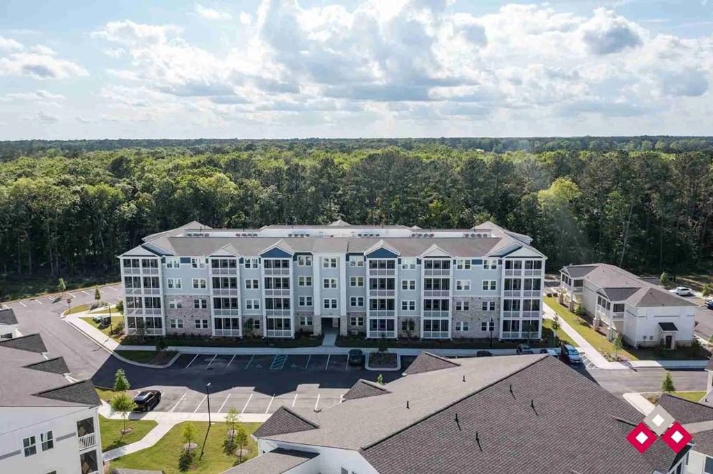 A large white building with a parking lot in front of it.