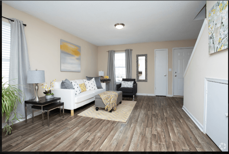 a living room with hardwood floors and beige walls