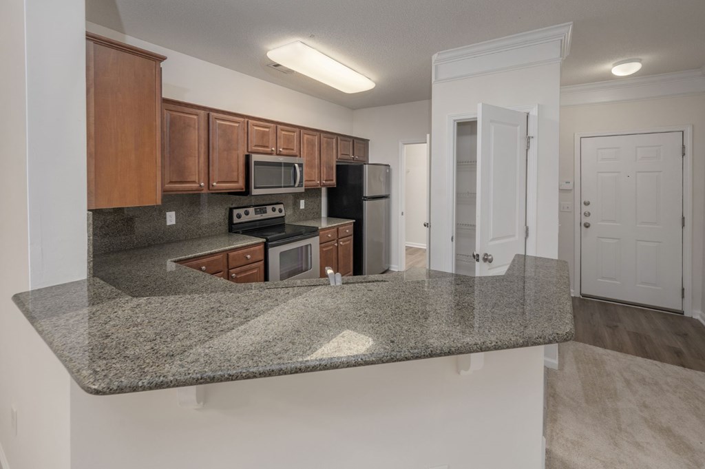 A kitchen with granite countertops and white walls.